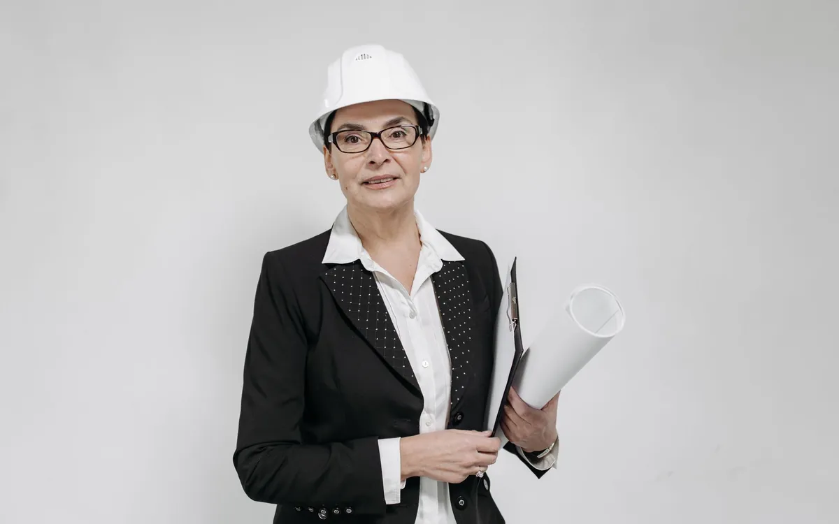 Specjalistka w kasku ochronnym z dokumentacją techniczną